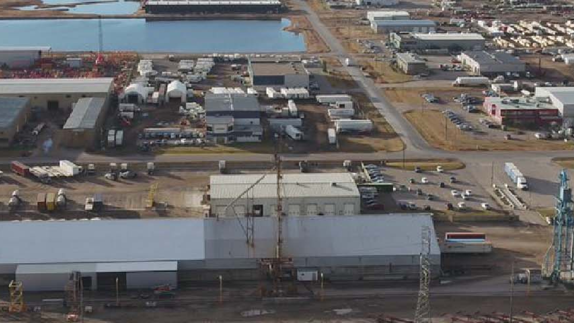 Aerial view of an industrial area with warehouses and water nearby.